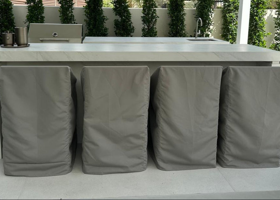 Outdoor kitchen setup with covered items on a patio